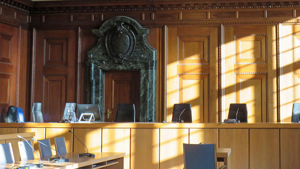 An inquest court with wood panelling, seats and microphones